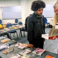 Two individual talking about a book